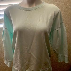 Mint colored sweatshirt with puffy sleeves.
